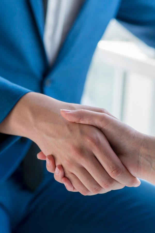 two-business-partners-shaking-hands-office_23-2147899631